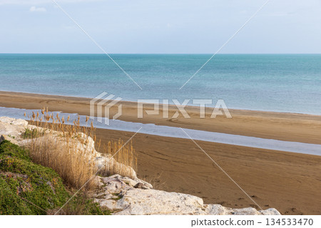 Serene landscape of a tranquil coastline, showcasing a wide sandy beach, Serene landscape of a tranquil coastline, showcasing a wide sandy beach, 134533470