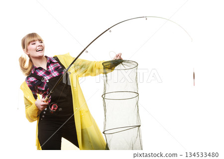 Happy woman holding fishing rod and keepnet Happy woman holding fishing rod and keepnet 134533480