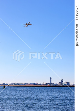 Passenger plane taking off into the blue sky_Vertical Passenger plane taking off into the blue sky_Vertical 134533750