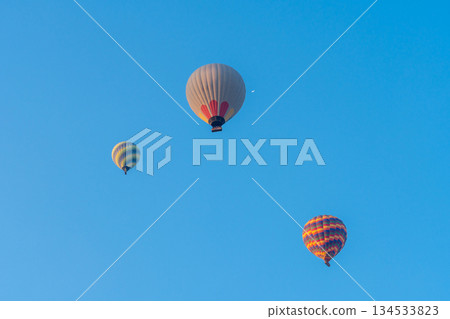 Three hot air balloons against a blue sky. Beautiful view of colourful hot air balloons from below. Cappadocia 134533823
