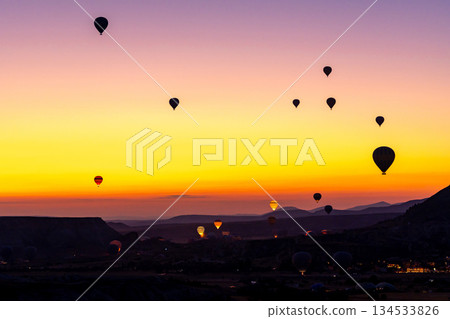 Hot air balloon flying over rocky landscape at sunrise in Cappadocia. Turkey 134533826