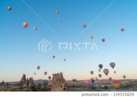 Hot air balloon flying over rocky landscape at sunrise in Cappadocia. Turkey Hot air balloon flying over rocky landscape at sunrise in Cappadocia. Turkey 134533829