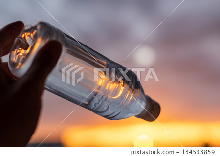 Transparent bottled water against the sunset sky | Landscape orientation 134533859