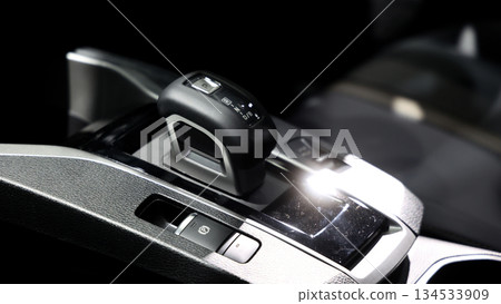 Car gear. Close up of modern car automatic gear selector or electronic shifter. Premium interior design EV car gears driving control. auto transmission modes. Automotive technology in motion driving. Car gear. Close up of modern car automatic gear selector or electronic shifter. Premium interior design EV car gears driving control. auto transmission modes. Automotive technology in motion driving. 134533909