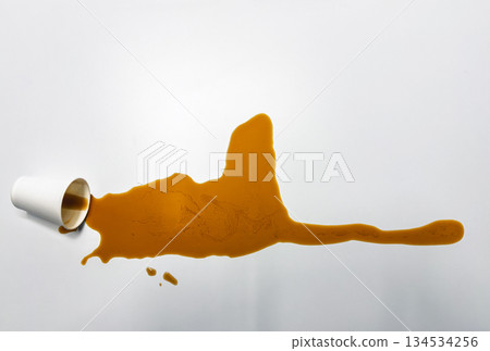 Accidental coffee spill on clean white surface top view representing morning rush deadline pressure and workplace distraction Accidental coffee spill on clean white surface top view representing morning rush deadline pressure and workplace distraction 134534256