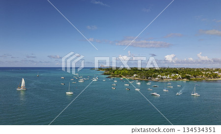 Scenic lagoon of Grand Baie Mauritius sailing boats near palm lined shore with Coin de Mire horizon Scenic lagoon of Grand Baie Mauritius sailing boats near palm lined shore with Coin de Mire horizon 134534351