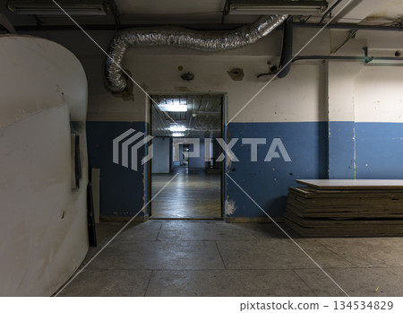 Long dark corridor in an old industrial building Long dark corridor in an old industrial building 134534829