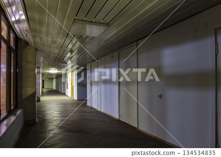 Long dark corridor in an old industrial building Long dark corridor in an old industrial building 134534835