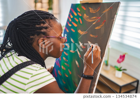 Artist paints vibrant colors in a bright studio Artist paints vibrant colors in a bright studio 134534874