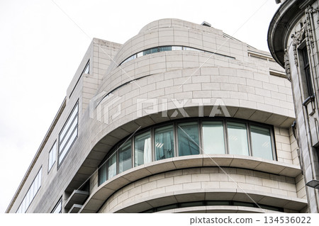 Modern Curved Stone Building Exterior with Large Windows 134536022