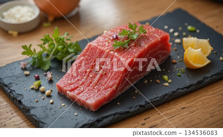 Fresh Fish Fillet Prepared on a Dark Stone Slab With Herbs and Lemon Slices in a Kitchen Setting 134536083