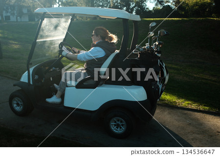 woman playing golf in the green fairway club woman playing golf in the green fairway club 134536647