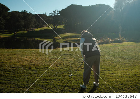 woman playing golf in the green fairway club woman playing golf in the green fairway club 134536648