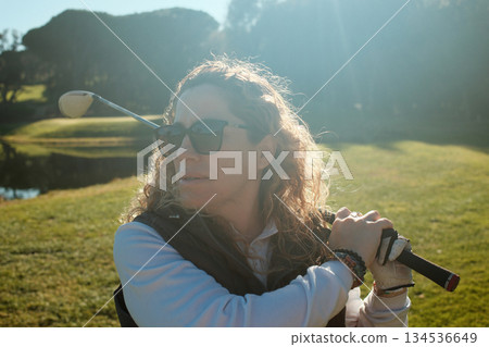 woman playing golf in the green fairway club woman playing golf in the green fairway club 134536649