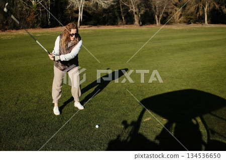 woman playing golf in the green fairway club woman playing golf in the green fairway club 134536650