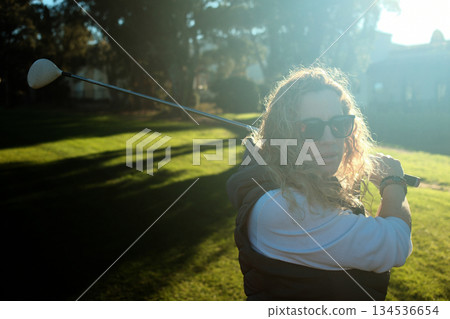woman playing golf in the green fairway club woman playing golf in the green fairway club 134536654