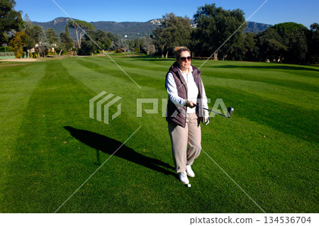 woman playing golf in the green fairway club 134536704