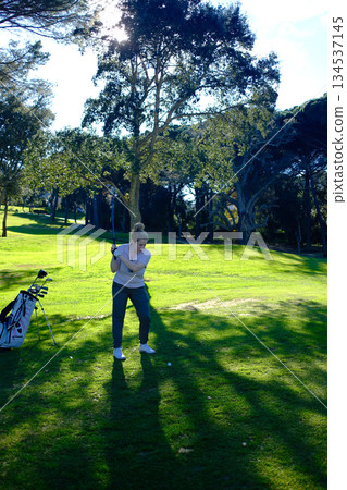 woman playing golf in the green fairway club woman playing golf in the green fairway club 134537145