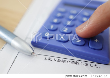 Image of a receipt and a blue calculator with the amount collected. Image of a receipt and a blue calculator with the amount collected. 134537183