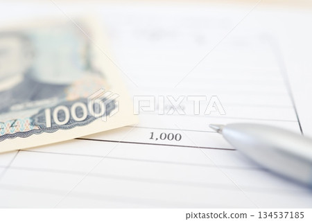 An image of payment shown with a 1,000 yen bill and a document showing the amount. An image of payment shown with a 1,000 yen bill and a document showing the amount. 134537185