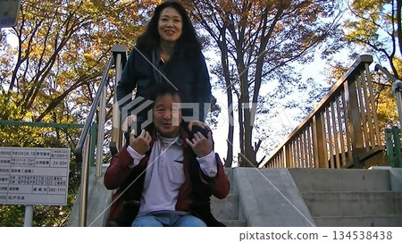公園裡,一位美麗的女子騎在別人的肩膀上。 公園裡,一位美麗的女子騎在別人的肩膀上。 134538438