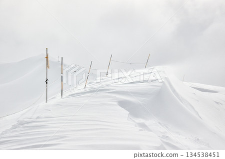 Winter high mountains in clouds 134538451