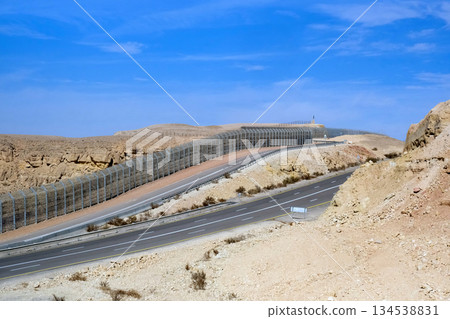 Highway and fence on the border with Egypt in the Eilat Mountains 134538831