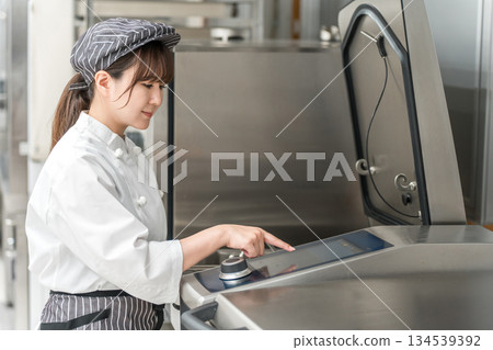 Female cooking staff using kitchen equipment 134539392