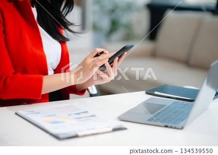 Businesswomen analyzing investment graph and discussing plan new start up project. 134539550