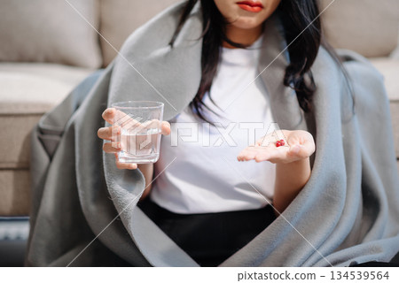 woman holding bottle with pills on hand going to take medicaments prescribed by his physician 134539564