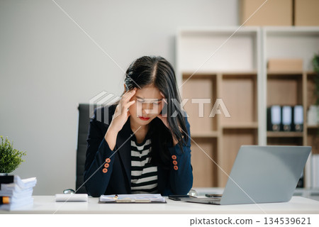 Asian business woman is stressed, bored, and overthinking from working on a tablet 134539621