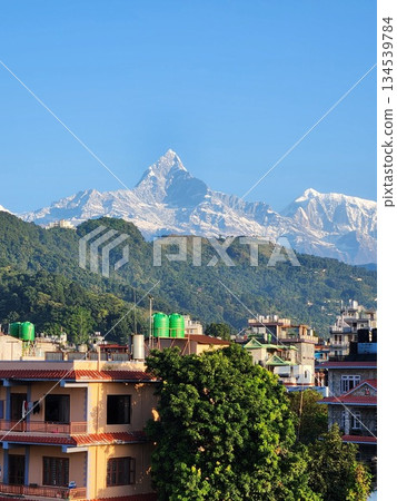 A distant view of the city of Pokhara, Nepal, and Machhapuchhre in the Himalayas A distant view of the city of Pokhara, Nepal, and Machhapuchhre in the Himalayas 134539784