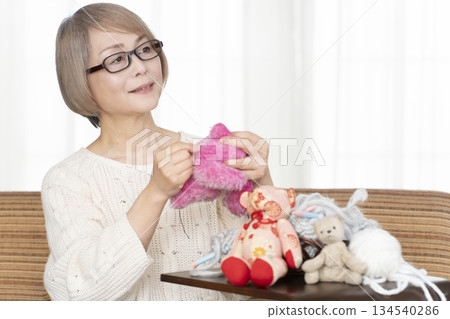 Senior woman making stuffing in the living room Senior woman making stuffing in the living room 134540286