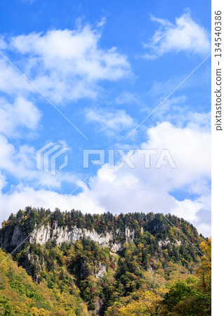 秋葉與藍天點綴著層雲峽的懸崖 | 阿寒摩週國立公園 134540386