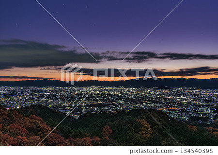 The pre-dawn scenery of the Nara Basin stretching out over the autumn leaves of Mt. Nijo 134540398