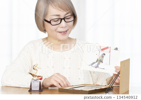 一位老婦人在客廳裝裱照片 134540912