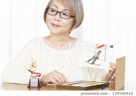 一位老婦人在客廳裝裱照片 134540914