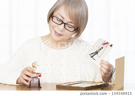 一位老婦人在客廳裝裱照片 134540915
