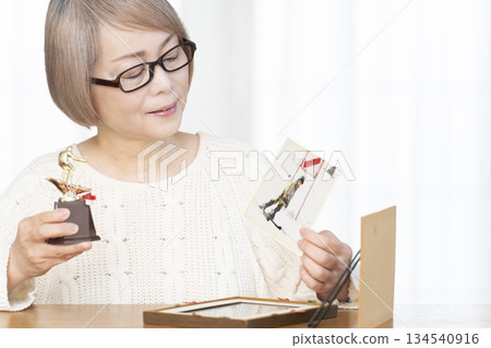 一位老婦人在客廳裝裱照片 一位老婦人在客廳裝裱照片 134540916