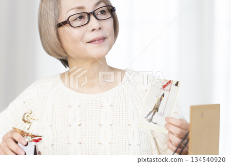 一位老婦人在客廳裝裱照片 134540920