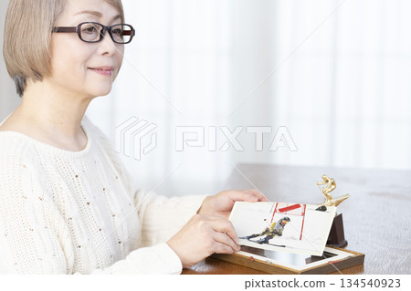 一位老婦人在客廳裝裱照片 一位老婦人在客廳裝裱照片 134540923