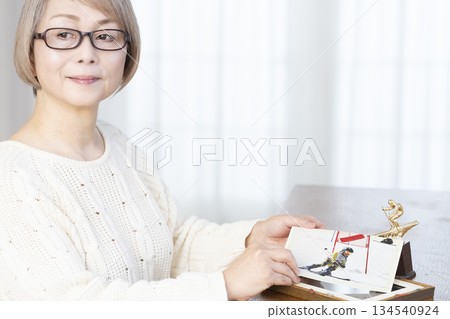 一位老婦人在客廳裝裱照片 134540924