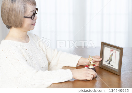 一位老婦人在客廳裝裱照片 134540925