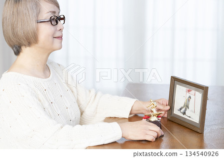 一位老婦人在客廳裝裱照片 134540926