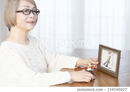 一位老婦人在客廳裝裱照片 134540927