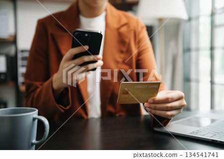 businesswoman hand using smart phone, tablet payments and holding credit card online shopping, omni channel, digital tablet computer 134541741