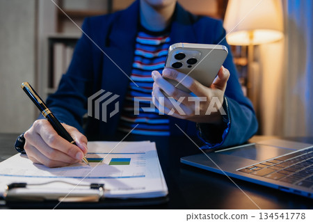 Women counting coins on calculator taking from the piggy bank. hand holding pen working on calculator at home office. 134541778