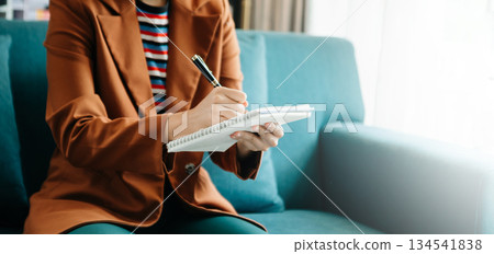businesswoman hand writing on the notepad on sofa 134541838