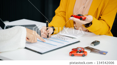 Asian people car salesman or sales manager offers to sell a car and explains of signing a car contract and signing car insurance 134542006