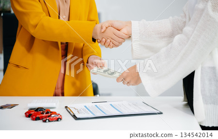 Asian people car salesman or sales manager offers to sell a car and explains of signing a car contract and signing car insurance 134542014